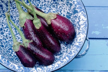 wet eggplants in a blue bowl