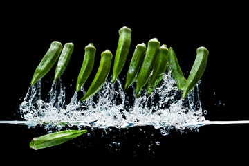 Fresh okra dropping into water creating splashes