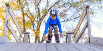 boy roller blading with helmet and knee pads