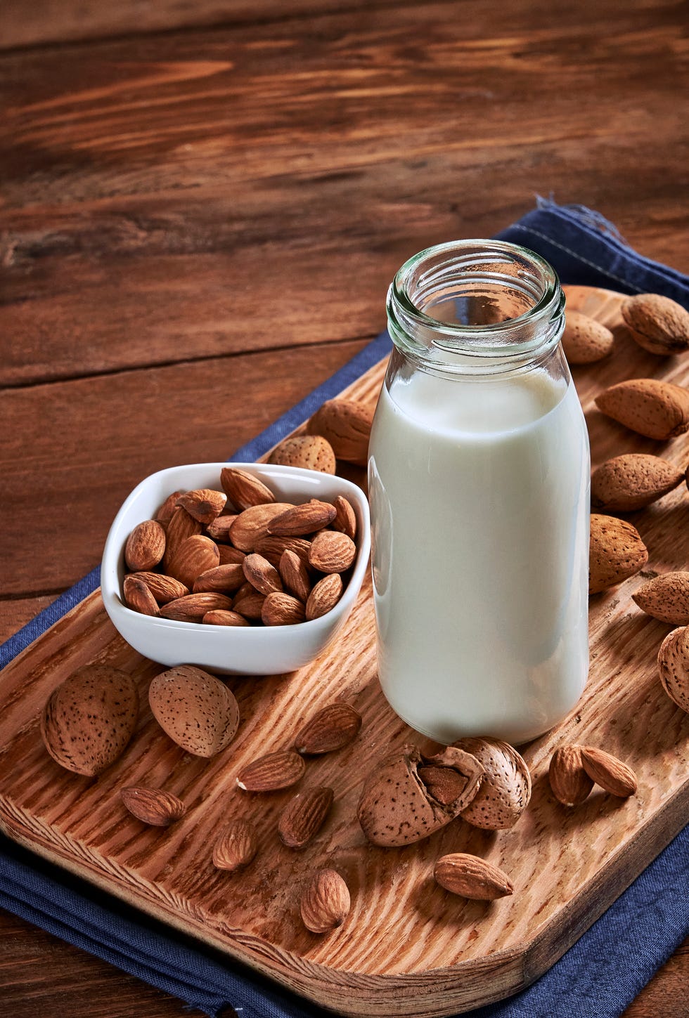 glass with almond milk on rustic wooden table with copy space