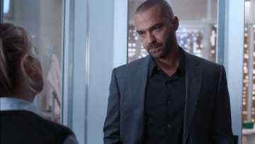 jesse williams as dr jackson avery in grey's anatomy season 21, wearing a black shirt underneath a grey jacket and looking very serious