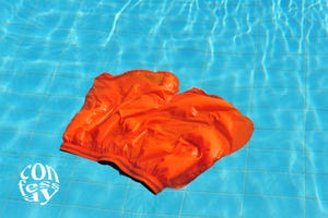 a pair of orange swim trunks lying on the bottom of a pool