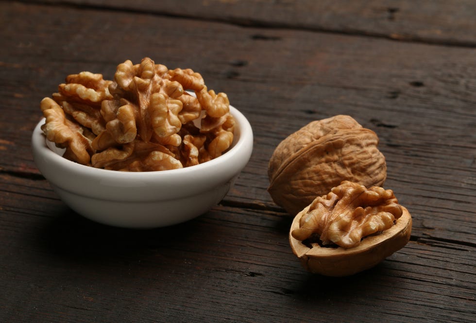 group of nuts in a bowl, over a wooden background