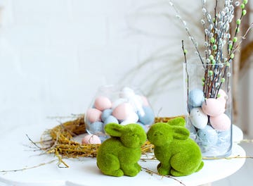 close up easter bunny rabbit statuette and basket with easter eggs easter egg hunt selective focus, copy space