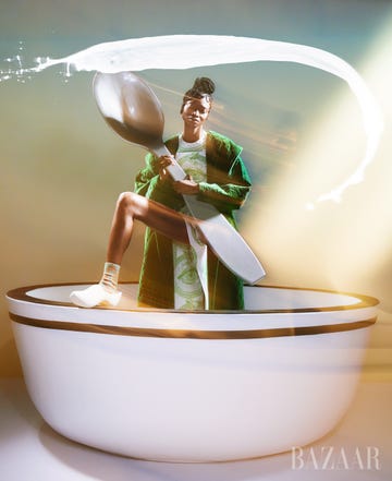 model holds giant spoon in tea cup