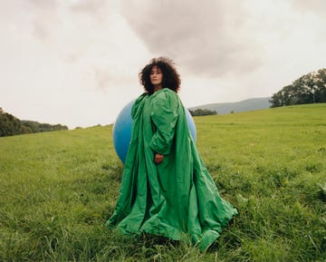 tracee ellis ross poses in green ensemble with large blue balloon in the background