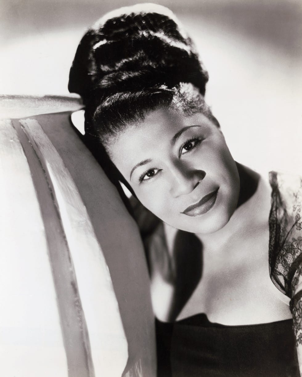 ella fitzgerald with her hair in a bun and leaning against a prop