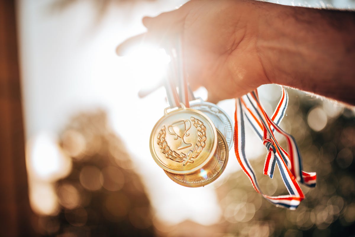 holding the medals for the winning