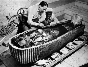 a couple of men working on a sarcophagus of king tut