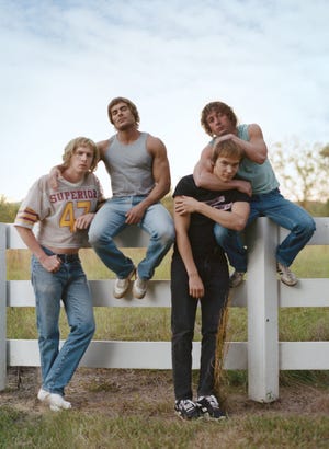 fictionalized von erich brothers from the iron claw posing for a photo in front of a white fence