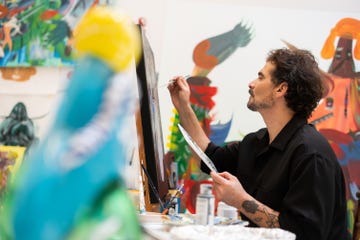 A person painting on an easel in an art studio