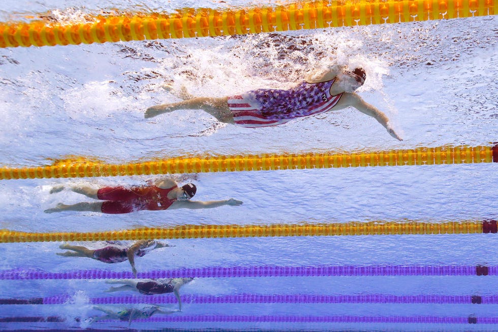 katie ledecky and several other swims race in lanes of a pool