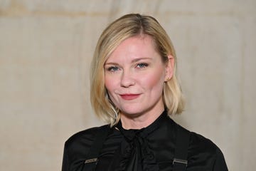 kirsten dunst wearing a black dress and looking straight ahead for a portrait photo