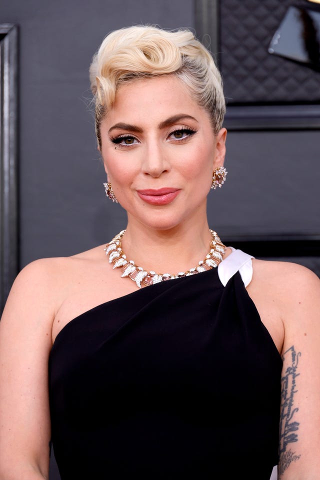 lady gaga poses in black dress at awards show