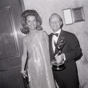 lee radziwill standing next to truman capote who is holding an emmy trophy and the both of them smiling