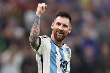 lionel messi wears an argentina soccer uniform and lifts one fist into the air while smiling
