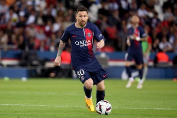 lionel messi looking upfield as he handles a soccer ball