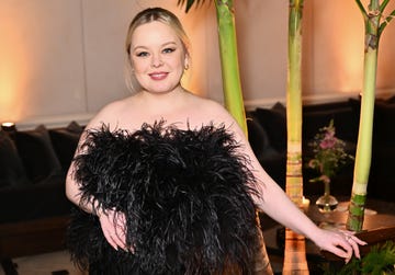 nicola coughlan wearing a black feathered dress and smiling in a photo