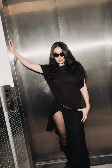 individual posing in an elevator with metallic backdrop