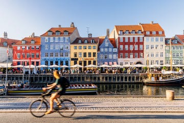 nyhavn harbour with restaurants and crowds of tourists on a sunny summer day, copenhagen, denmark