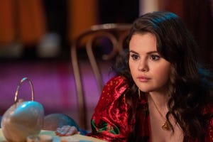 selena gomez in character for only murders in the building, she looks to the left and wears a red dress