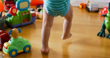 baby walking next to toys