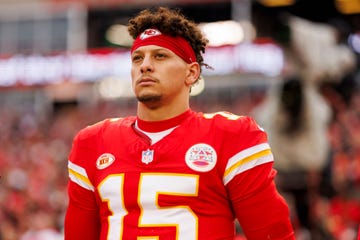 patrick mahomes gazes into the distance, he wears a red football uniform with the number 15 on his jersey and a red kansas city chiefs headband