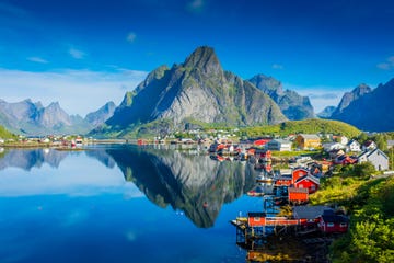 perfect reflection of the reine village on the water of the fjord in the lofoten islands, norway