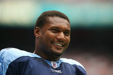 steve mcnair smiling and waering his titans nfl uniform