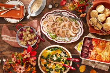 a table set with plates of food including turkey roulade, winter salad, biscuits, root vegetable gratin, and sweet and sour onions