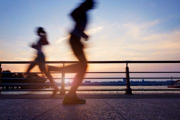 people running outside in a city near water