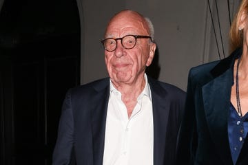 rupert murdoch wears a suit jacket, a white collared shirt that is unbuttoned at the neck and tortoise brown glasses