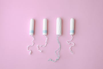 sanitary tampons for menstruation period over pink background female health care concept