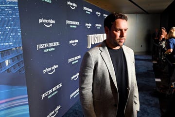 scooter braun looking offscreen at photographers in front of a backdrop