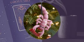 a decorative scorpion ornament hangs amid holiday decorations along with a tarot card book and a candle