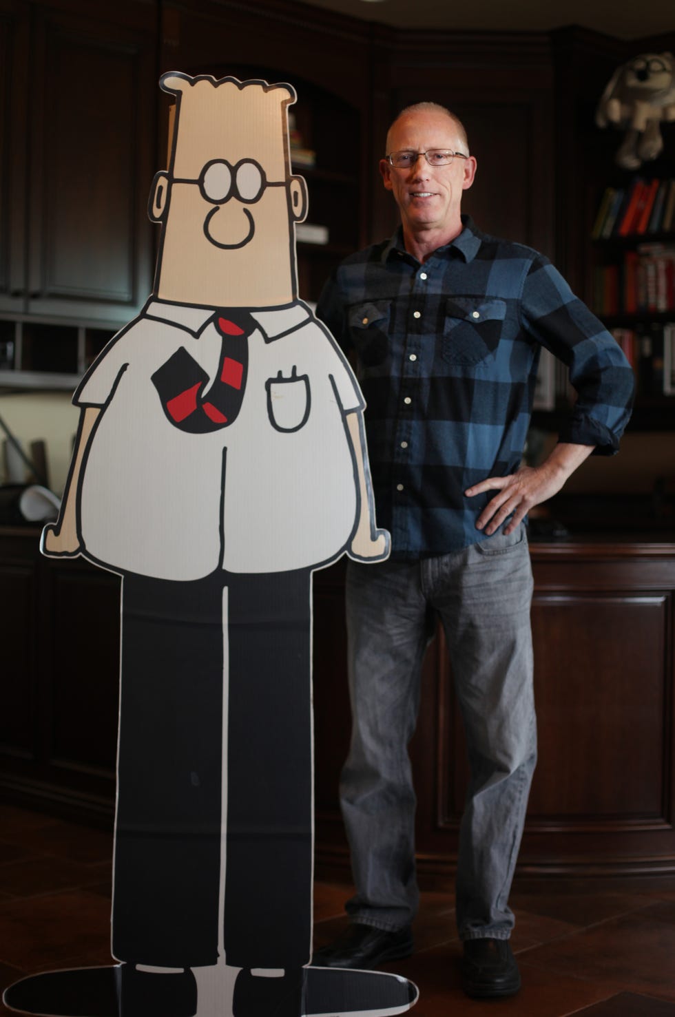 cartoonist scott adams standing with cutout of dilbert comic strip character