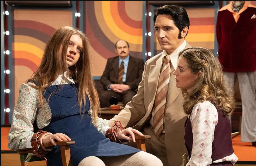 a man and woman sitting next to each other and looking at each other