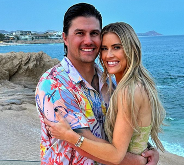 a man and woman posing for a picture on a beach