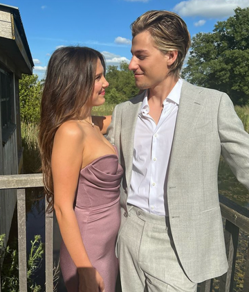 a man and woman standing next to each other outside