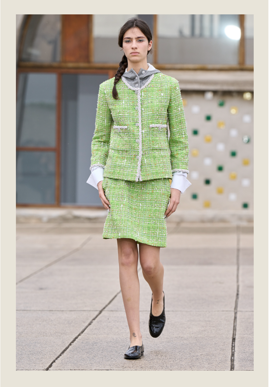 model wearing a green textured twopiece outfit on a runway