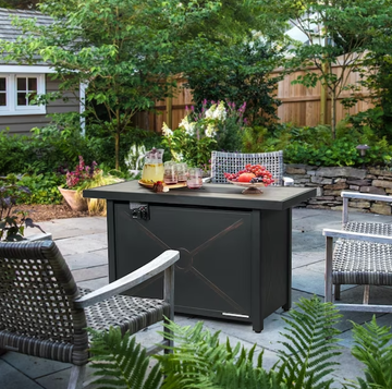 a grill outside with chairs and a table in the back