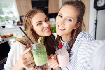 selfie of happy friends holding smoothies