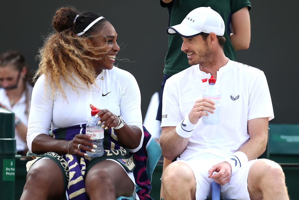 serena williams and andy murray smile at each other while sitting on the side of a tennis court, each holds a water bottle