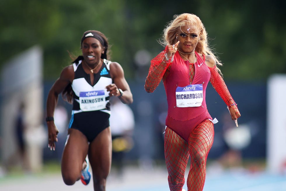 women running in a race while wearing a pink leotard and a red fishnet body suit