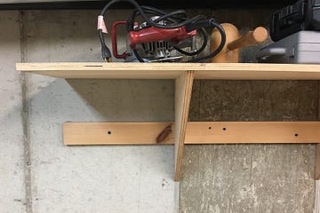 a wooden shop shelf holding some equipment