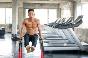 muscular man doing l sit position on parallel bars workout at gym healthy lifestyle, exercising and people concepts