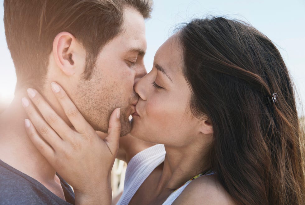 spain, majorca, young couple kissing on boardwalk, close up