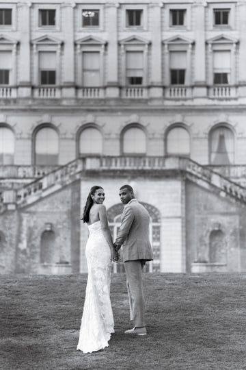 a man and woman posing for a picture in front of a building