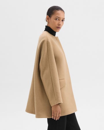 model wearing a tan coat and black turtleneck