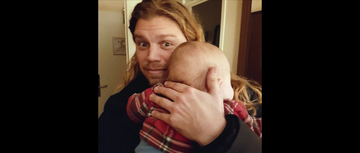 jonathan meijer holding a baby and looking forward into a camera in a screenshot from 'the man with 1000 kids'
